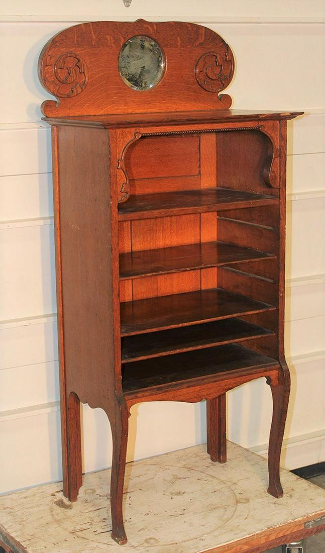 Oak Mirrored Back Music Cabinet: Oak mirrored back music cabinet by the novelty MFG. Co. Syracuse NY. Original finish, has rubs and dings. Missing 2 shelves, mirror needs silvering. 22" wide, 49" tall, 13" deep.