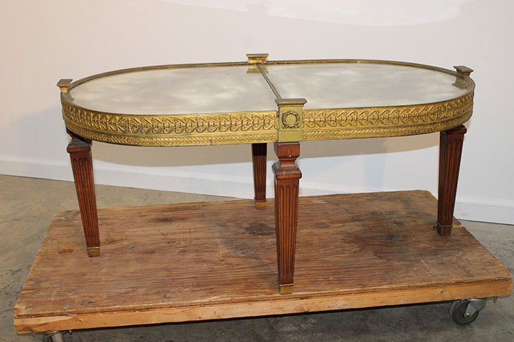 Neat coffee table with mirrored top and heavy brass skirting. Probably centennial, wreath design (1 of 5)