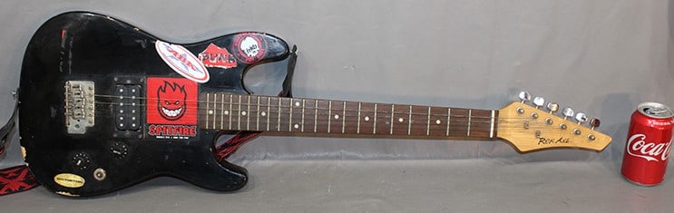 Small Rok Axe electric guitar. Been used, has dings and chips. Stickers missing 2 strings. 36" long.: Small Rok Axe electric guitar. Been used, has dings and chips. Stickers missing 2 strings. 36" long.