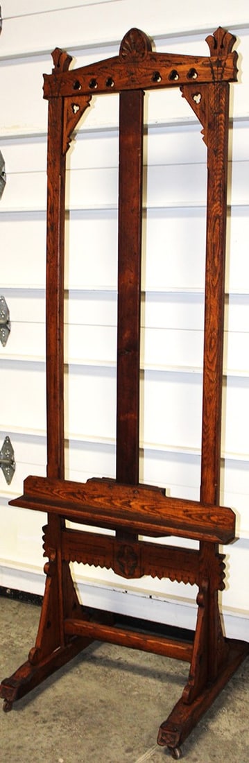 Eastlake Chestnut Easel With Gothic Motif: Eastlake Chestnut easel with gothic motif. Has fancy carvings, middle board that holds the support has been replaced. 28" wide, 77" tall, 24" deep.