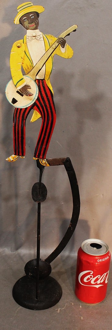 Vintage Moving Black Man Playing A Banjo: Vintage moving black man playing a banjo in nice paint. His head and arm moves while he swings back and forth. 22" tall.