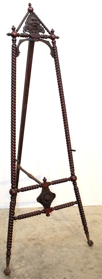 Merklen brothers easel with northwind head top. Claw and ball feet, rope twist posts in original: Merklen brothers easel with northwind head top. Claw and ball feet, rope twist posts in original finish. Frame pegs are replaced. Painting not included. 29" wide, 73" tall.