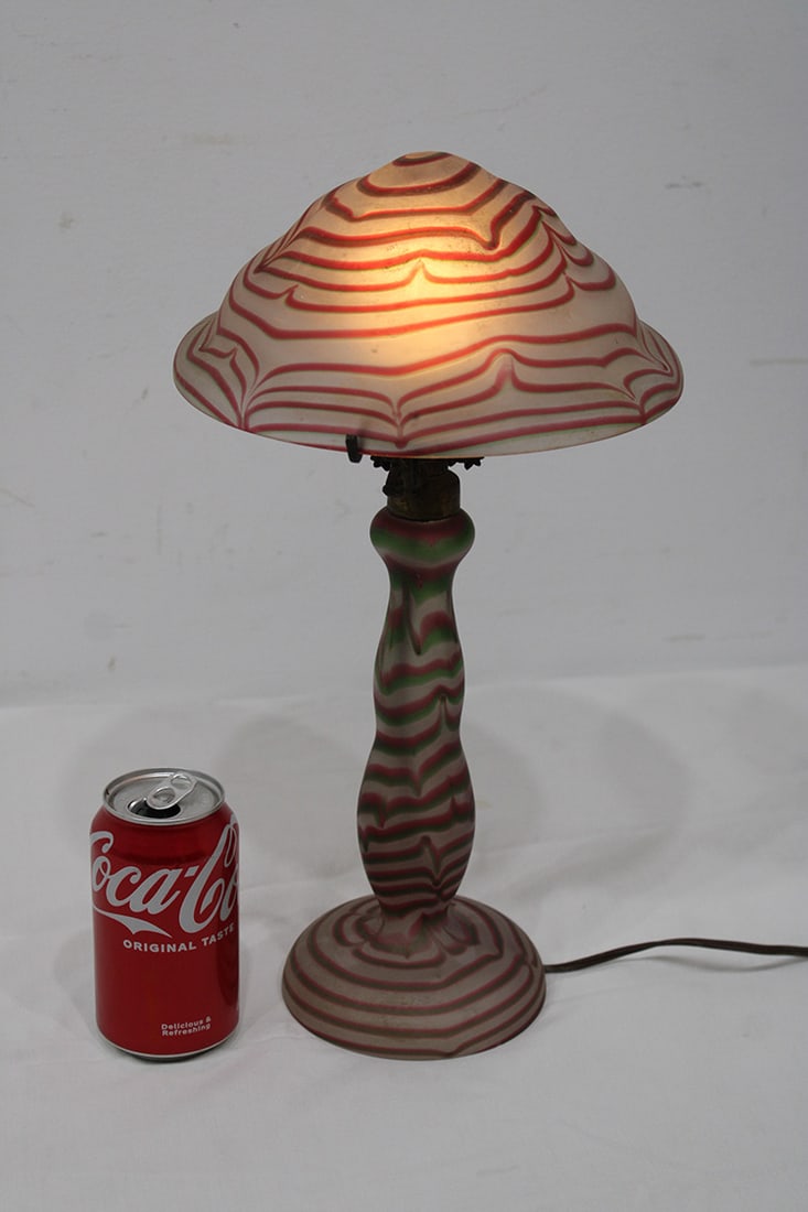 Nice Antique Art Glass Lamp With A Ribbon Design: Nice antique art glass lamp with a ribbon design in nice condition. Very pretty shade. Has a tiny flick (see photo). 9" wide, 15" tall.