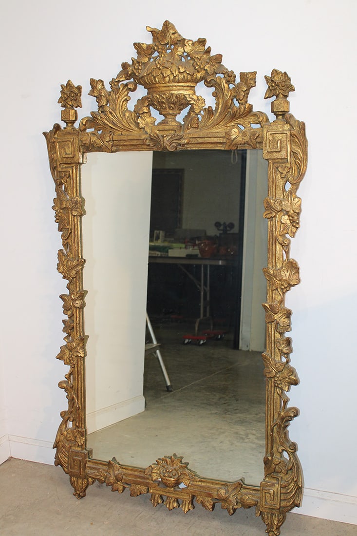 Large hand carved Italian gilded mirror. Has a basket of fruit crest and grape vines down the side.: Large hand carved Italian gilded mirror. Has a basket of fruit crest and grape vines down the side. Very intricately carved, West Stockbridge estate. Nice condition. Appr. size is 30" wide, 56" tall.