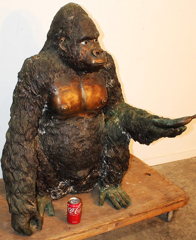 Unusual Large 40" Bronze Gorilla Sculpture Holding A Banana: Unusual large 40" bronze gorilla sculpture holding a banana. Nice 2-tone patina, glass eyes. Can be displayed inside or outside. Appr. 31" wide, 40" tall, 29" deep.