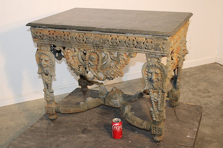 Incredible Cast Iron Marble Top Patio Table With Heads And Cherubs: Incredible cast iron marble top patio table with heads and cherubs. Very heavy with a marble granite top. All iron and marble are in nice condition from an upstate NY camp. 35" wide, 28" tall, 24" dee