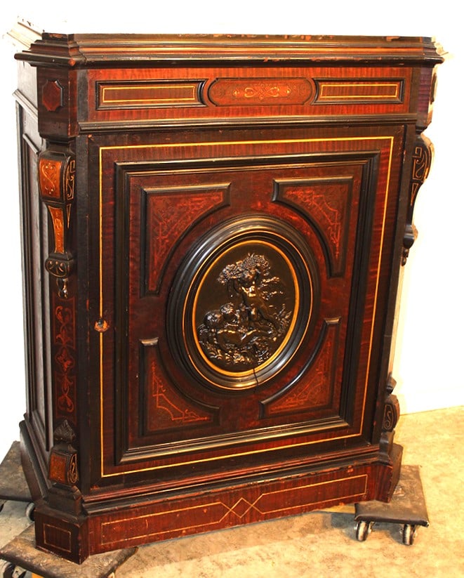 Fancy Renaissance 1 Door Credenza With An Oval Bronze Plaque: Fancy Renaissance 1 door credenza with an oval bronze plaque with a cupid scene. Black and gold incising. Missing moldings and has chipping on the veneer. 35" wide, 42" tall, 18" deep.