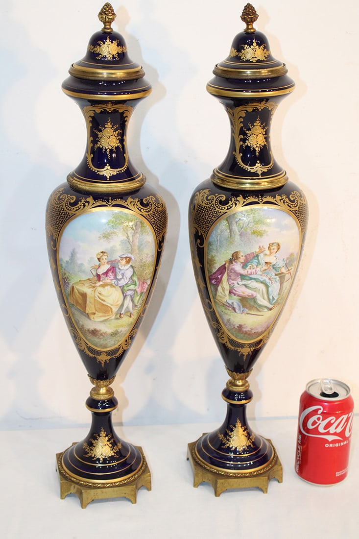 Fabulous Pair Of Hand Painted Artist Signed (19Th) Sevres Urns 22": Fabulous pair of hand painted artist signed (19th) Sevres urns 22". Artist signed R. Couton, bronze ormalu and cobalt blue in nice condition with courting scenes and gold gilt accents.