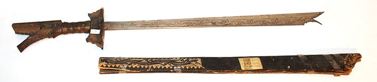 Early 18th or 19th Century Sword (Kampilan): Early 18th or 19th Century Sword (Kampilan). Labeled Moro Kampilan from lake Lanao Island of Mindanao, with an engraved blade. With a carved bifurcate and a 2 piece wooden scabbard. Sheffield estate. 
