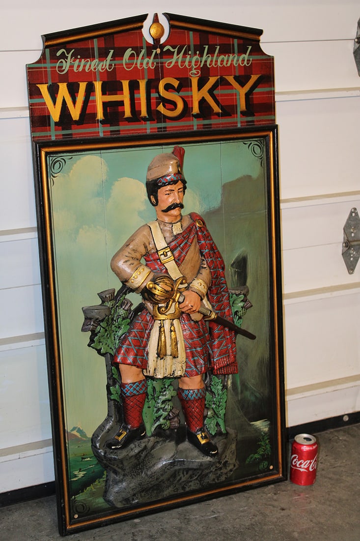 Vintage Hand Painted "Old Highland Whiskey" Sign: Vintage Hand Painted "Old Highland Whiskey" Sign. With a 3-D relief carving of a traditional highlander with nice paint. In good condition, Vermont estate. 24" wide X 46" tall X 3" deep.