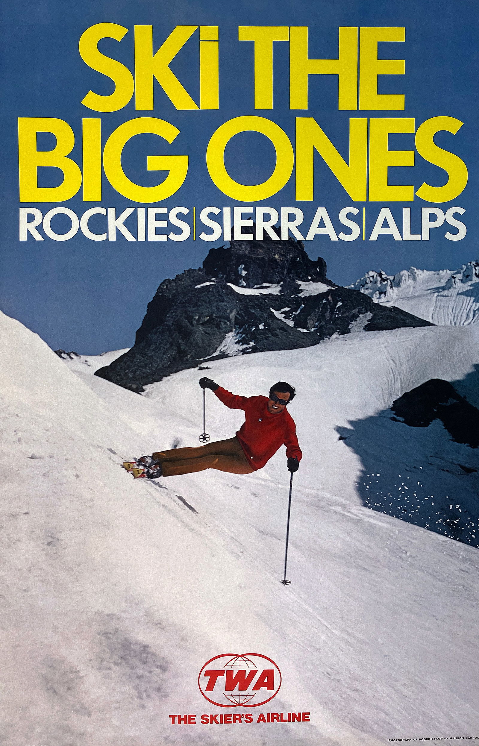 Original Vintage TWA Ski The Big Ones Poster C1965: This dynamic travel poster produced for Trans World Airlines captures the exhilaration and scale of world-class skiing during the golden age of jet travel. A lone skier carves confidently through fres