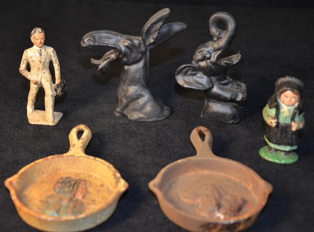 Cast Iron lot: This lot of cast iron includes two small cast iron frying pans, amish lady, two political elephant/ donkey pieces and a man in white suite.