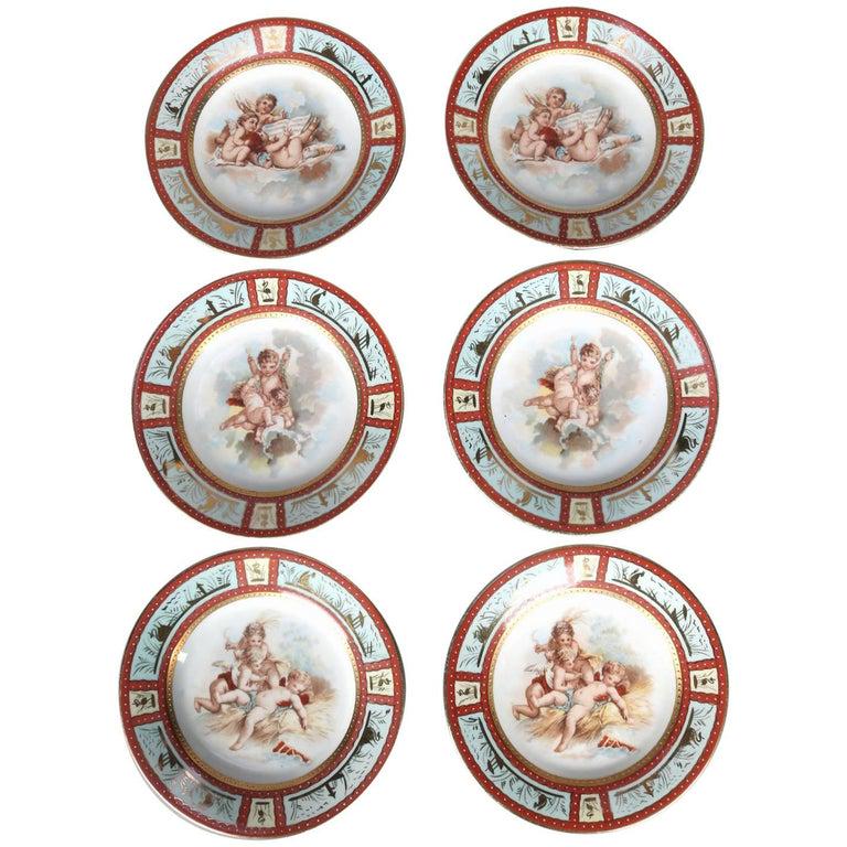 Six Antique Royal Vienna Classical Hand-Painted: Six antique hand-painted plates by Royal Vienna feature central classical cherub scenes, borders with reserves of marsh scenes with herons and grasses including cattails, en verso blue shield or beehi
