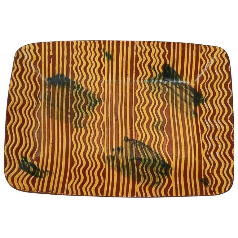 Oversized Pennsylvania Earthenware, Combed Slip Glaze: A Pennsylvania Lancaster County oversized red ware (earthenware) tray offers rectangular form with combed slip glaze decoration with ruffled rim and verso artist signed, 20th century Measures: 1.5" H 