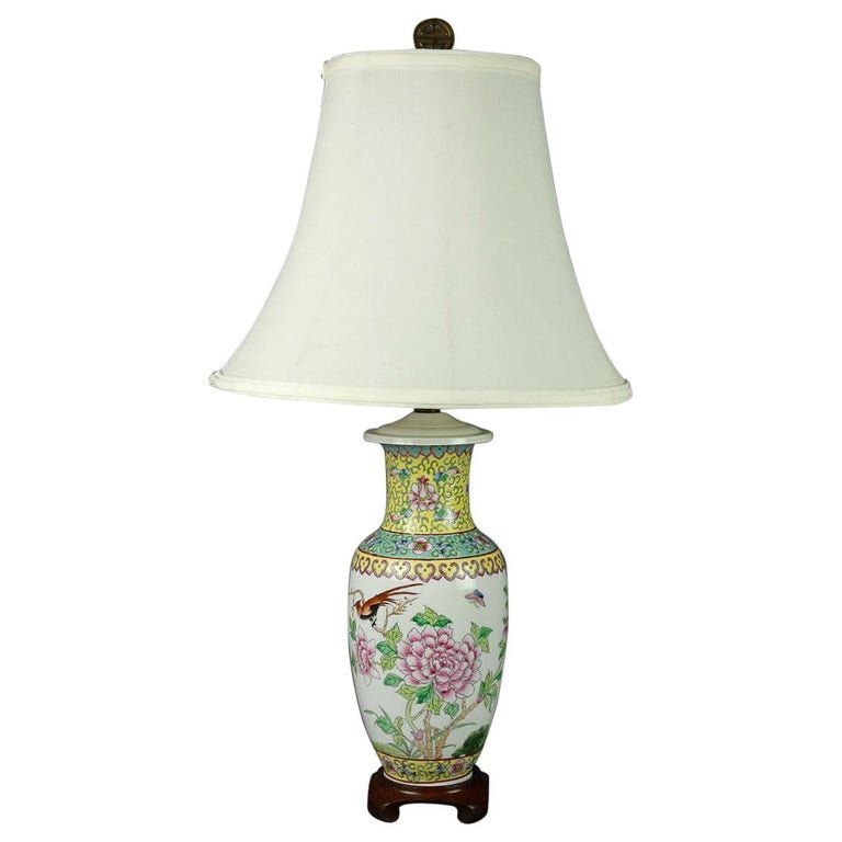Vintage Chinese Hand Painted Floral Garden Table Lamp: A vintage Chinese table lamp offers lidded porcelain vase in hourglass form with hand painted garden scene of flowers and birds, collar and base with repeating stylized foliate and scroll pattern band
