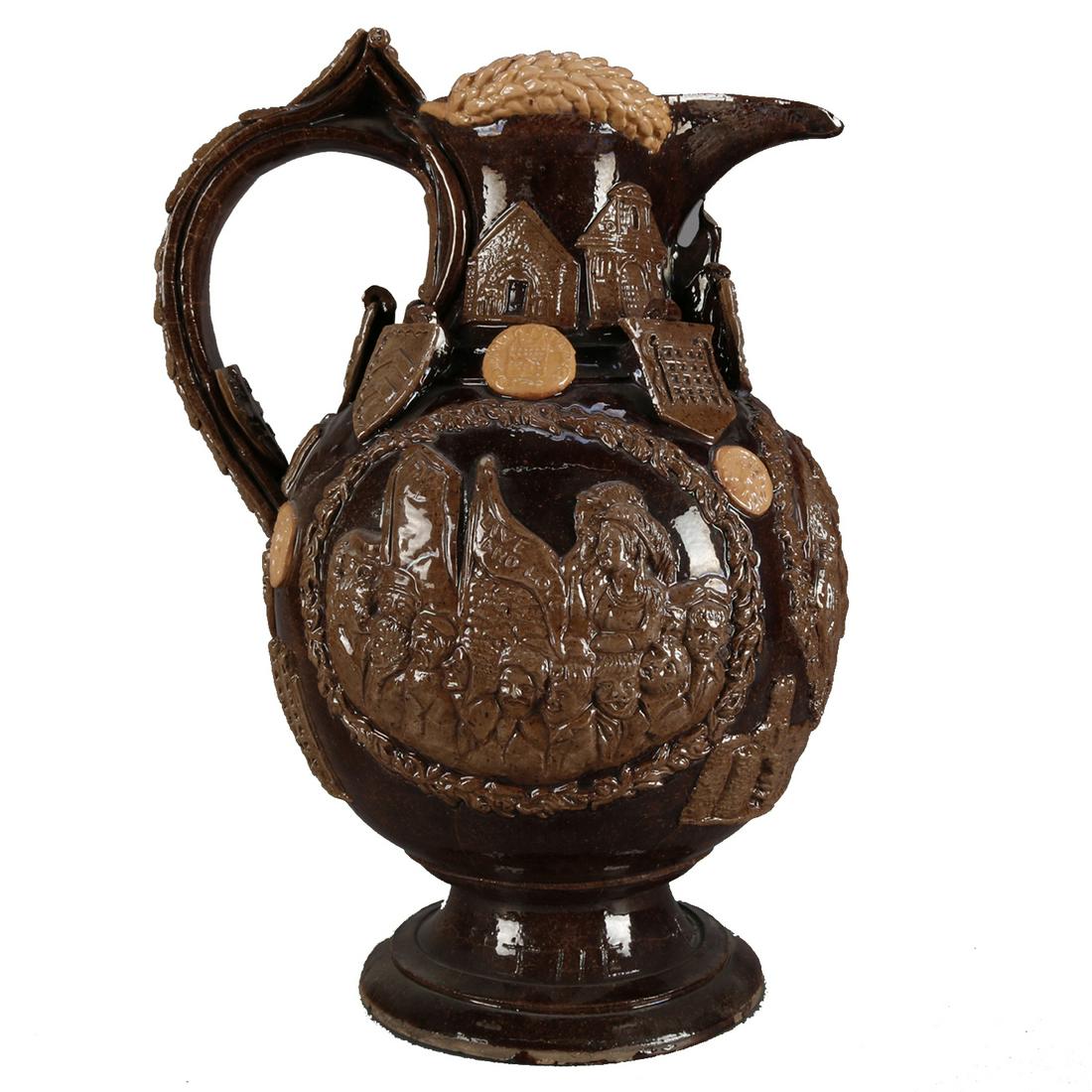 English Pottery Essex Jug by Castle Heingham: A Castle Hedingham Essex Jug by Edward Bingham, offers bulbous form with strap handle, all over relief decorated with symbols relating to Essex including shields of the Earls of Essex, profiles of Ess