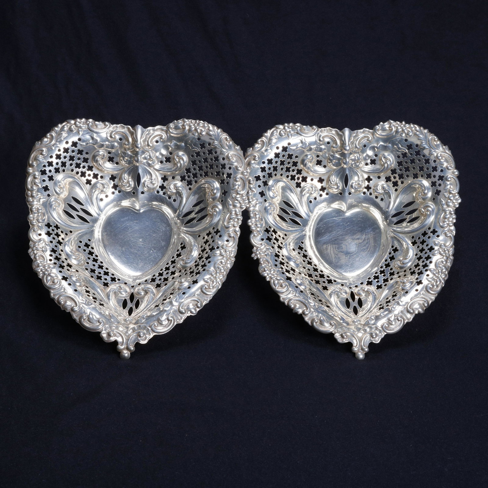 2 Lg Sterling Silver Gorham Heart Reticulated Nut Bowls: Pair Large Sterling Silver Heart Form Reticulated Nut Bowls by Gorham offer embossed scroll and foliate decoration and raised on ball feet, marked on base as photographed, 19.6 toz, 20th century. Meas