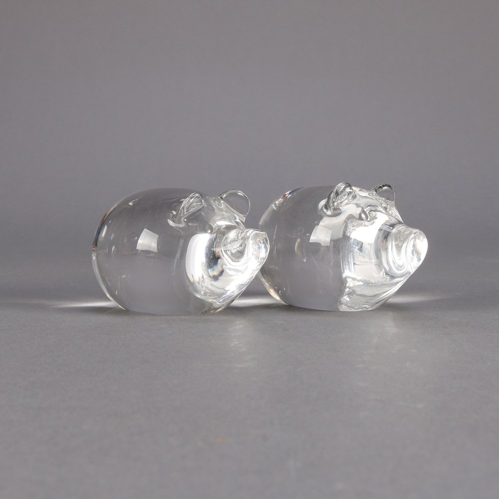 Pair Steuben Figural Crystal Pigs: A pair of Steuben figural art glass pigs, one signed and one frosted base, colorless, 20th century.Measures - 2.5" h x 3.5" w x 1.5" d***IN-HOUSE SHIPPING & DELIVERY QUICK QUOTES AVAILABLE UPON REQUES