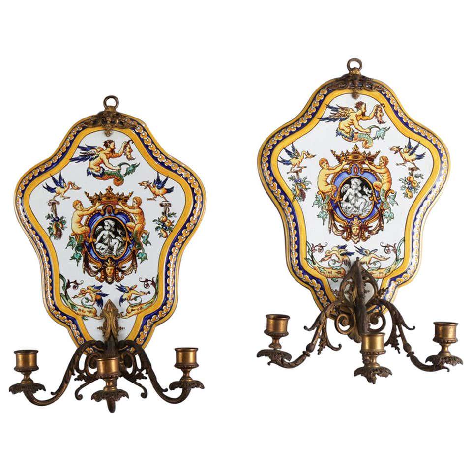 Pair of Majolica School Hand-Painted Faience Pottery: Pair of Italian Majolica School Faience pottery wall sconces by Gien of France feature shield shape with hand painted classical cherub scenes and having bronze attachments including upper wall hanger