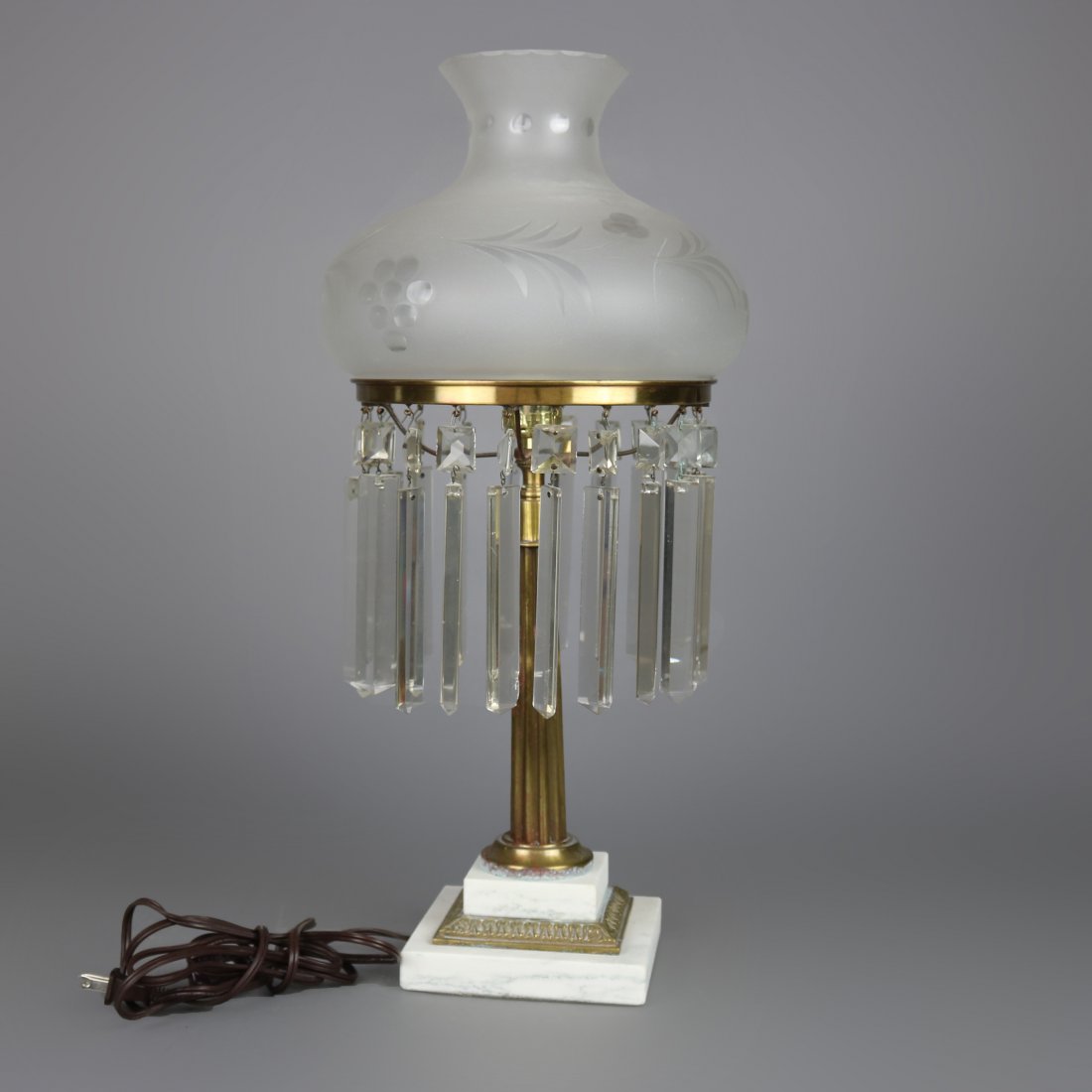 Antique Sinumbra Style Gilt Metal & Marble Table Lamp: An antique Sinumbra style table lamp offers etched frosted shade with hanging prisms surmounting gilt metal single socket base having reeded column seated on stepped marble base, circa 1930. Measures
