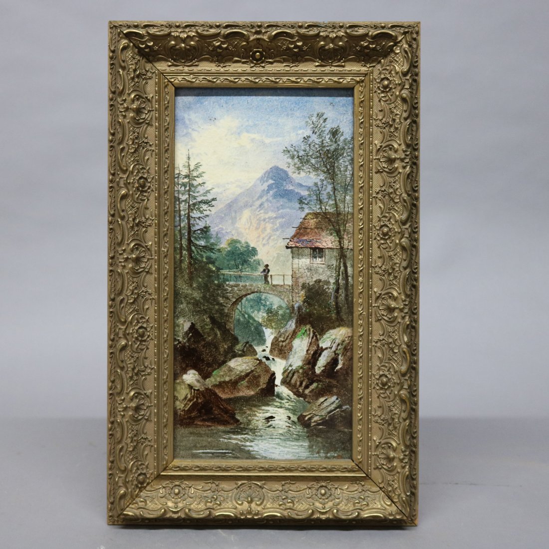 Antique Signed Swiss Landscape River Painting on Tile: An antique landscape painting on tile depicts stream scene with bridge, figure and structure in mountainous setting, en verso signed as photographed, seated in gilt frame, circa 1890. Measures - 21.75