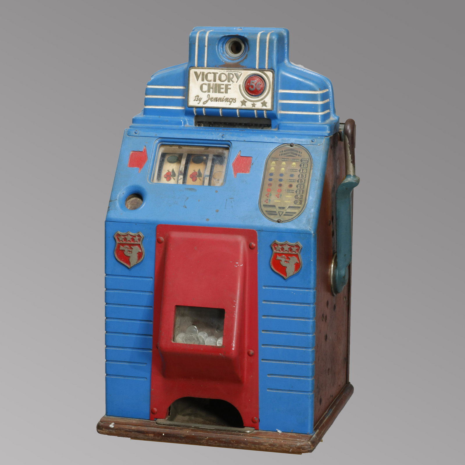 Antique Victory Chief Arcade or Casino Slot Machine: An antique Victory Chief arcade or casino 5 cent coin (nickel) slot machine "One Armed Bandit" by Jennings offers blue and red enamel painted metal construction, circa 1930. Measures - 27.5" H x 16.5"