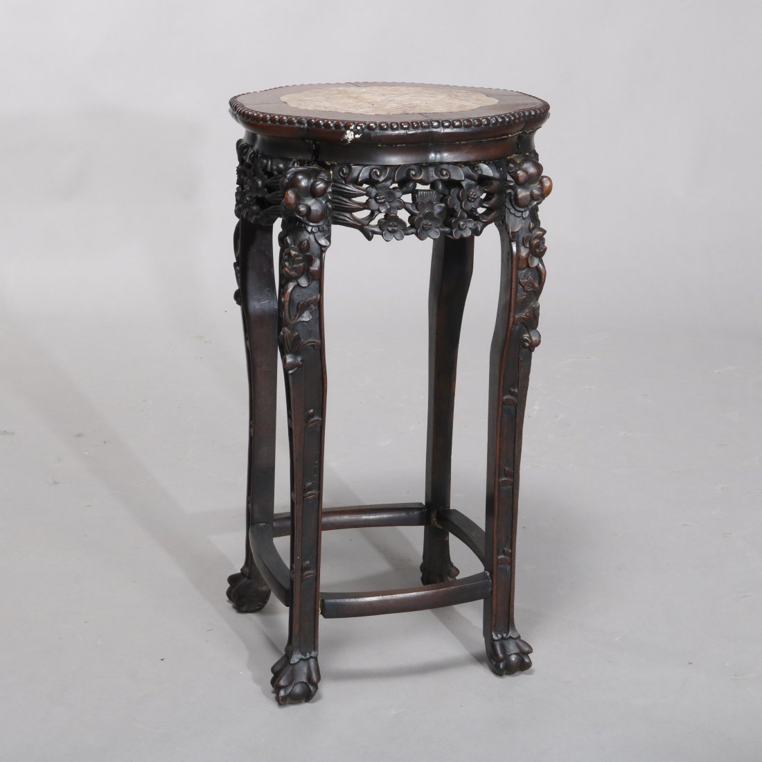 Antique Chinese Carved Rosewood Marble-Top Plant Stand: An antique Chinese plant stand offers shaped inset marble-top over carved rosewood stand with pierced floral form skirt, raised on cabriole legs terminating in paw feet, circa 1900. Measures- 27.25" H
