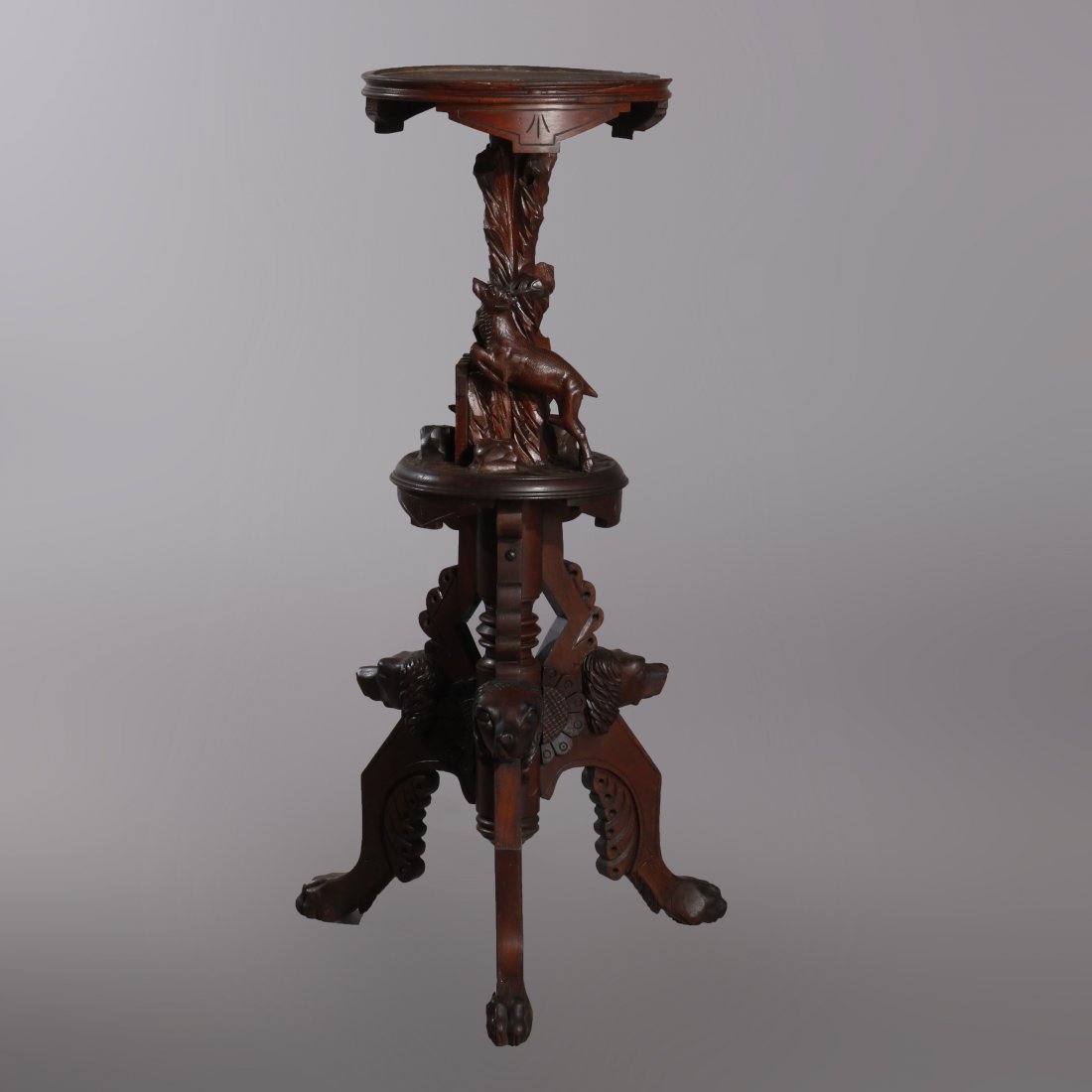 German Carved Walnut Figural Black Forest Plant Stand: An antique German figural Black Forest plant stand offers carved walnut base having various game masks and central full stag, raised on tripod base with paw feet, without marble top, circa 1880. Measu