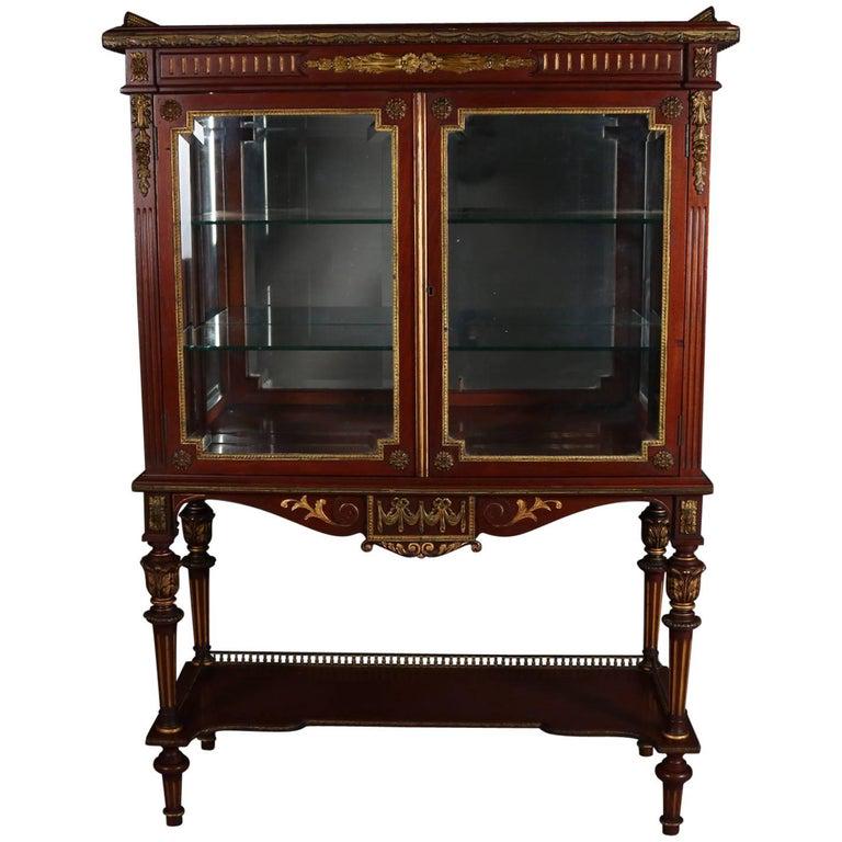 Antique French Louis XVI Style Mahogany, Ormolu Vitrine: Antique French Louis XVI style vitrine features mahogany construction, cast bronze accoutrements and upper gallery, gilt highlights, swag and foliate decorated apron, two glass front doors opening to 
