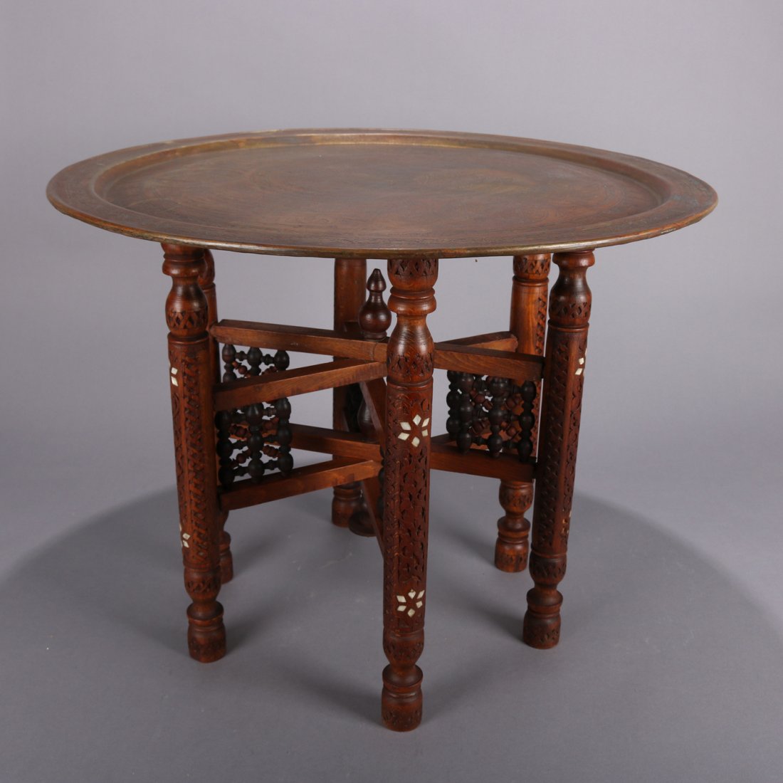 Moorish Musharabie Carved Wood & Mother-of-Pearl Stand: Moorish Musharabie Carved Wood and Mother-of-pearl Inlaid Brass Top Stand.Antique Anglo-Indian tray table features Persian brass tray top incised with Moorish designs, seated on Middle Eastern carved 