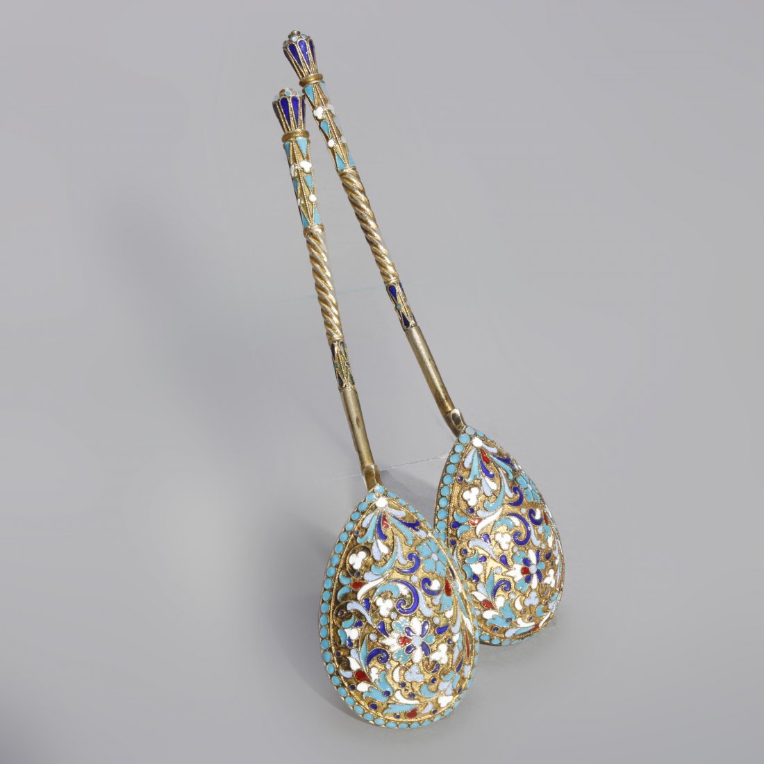 Antique Russian Enamel 84 Silver Long Spoons, C1900: An antique pair of Russian long spoons offer 84 silver with teardrop bowls, scroll and foliate enamel decoration throughout, unmarked, c1900. Measures- 6.88" H x 1.5" W x 1.63" D. ***IN-HOUSE SHIPPING