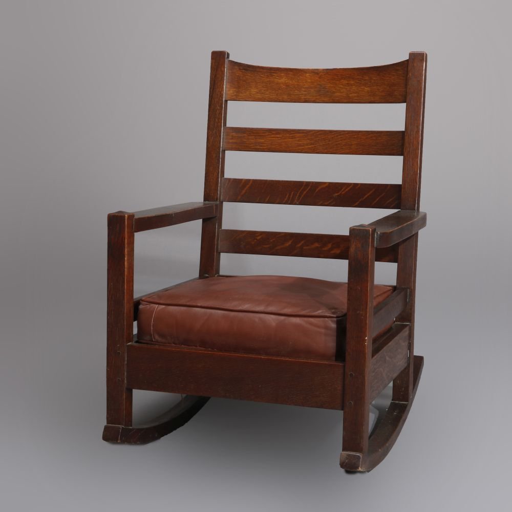 Early Gustav Stickley Arts & Crafts Mission Oak Rocker: An early Gustav Stickley Arts and Crafts Mission Oak rocker offers slat back with leatherette back and seat cushion, original finish, c1910. Measures - 36.25"H x 25.5"W x 27.5"D ***IN-HOUSE SHIPPING &
