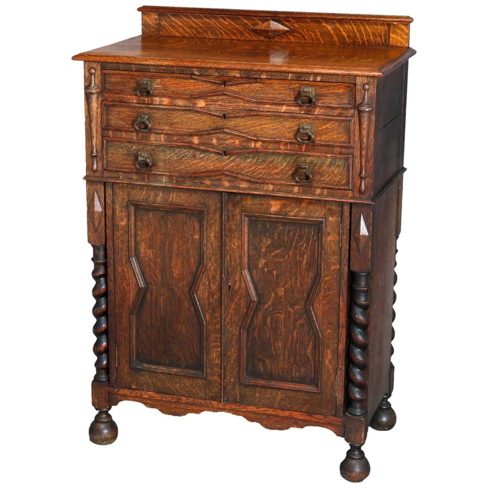 Antique Elizabethan Carved Oak Silver Chest: An antique Elizabethan silver chest offers quarter sawn oak construction with backsplash having carved pyramidal element over beveled top surmounting case with silver drawer having flanking stylized u