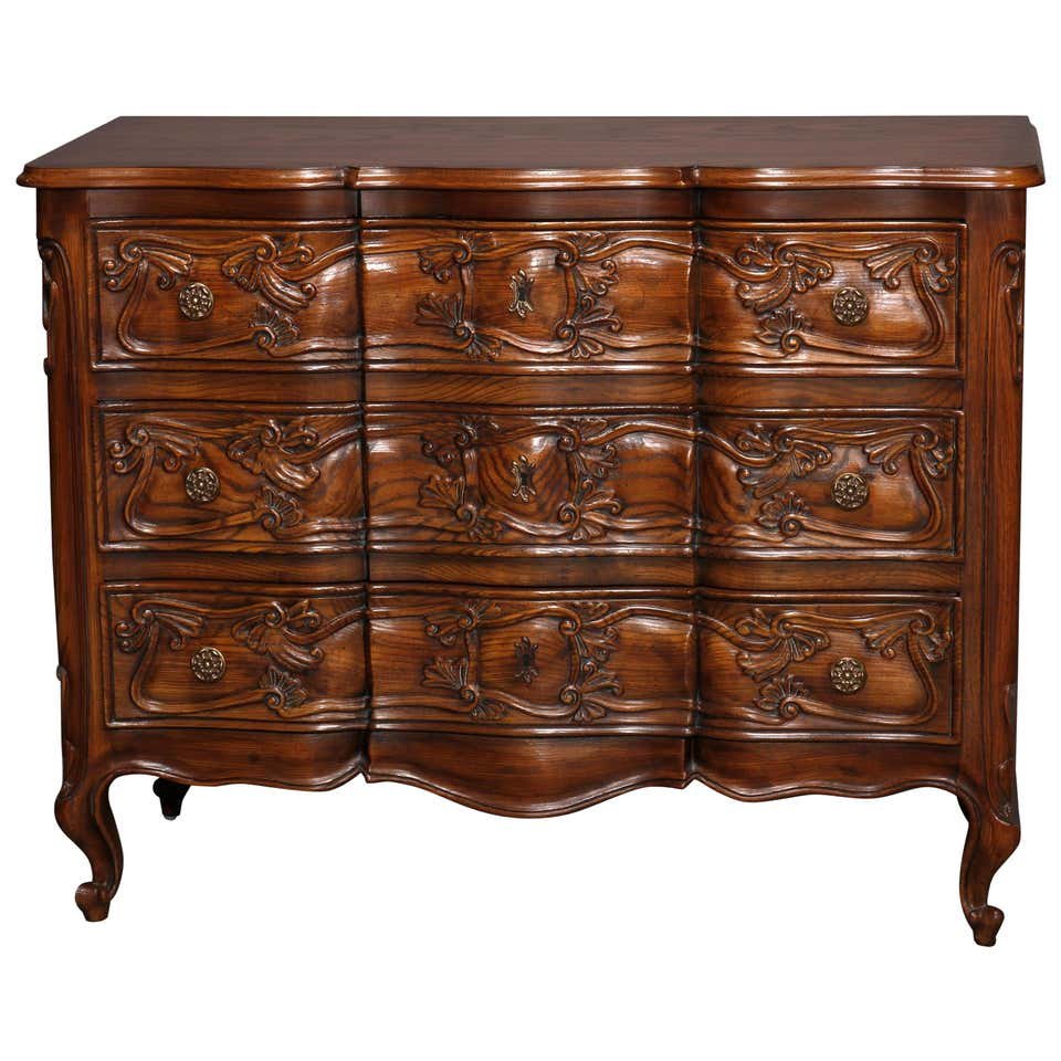 Henredon Oak Louis XIV Carved Swell Front Commode,20thC: An antique French Louis IV style chest of drawers by Henredon offers oak construction with shaped top surmounting swell front chest with three shaped drawers having carved foliate elements, paneled si