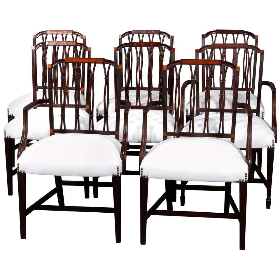 8 Hepplewhite Style Mahogany & Satinwood Dining Chairs: An antique set of eight English Hepplewhite style dining chairs offer mahogany frames with slightly arched backs having satinwood inset crest surmounting stylized reeded ribbon backs over upholstered