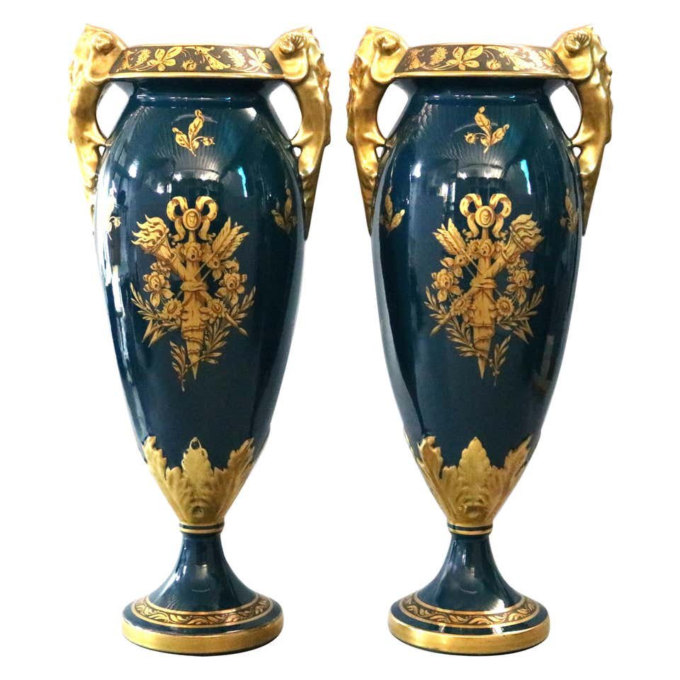 Pair Oversized French Jacob Petit Figural Limoges Vases: An antique matching pair of oversized French Limoges porcelain vases by Jacob Petit Figural offer urn form with gilt floral rim having double figural Satyr handles surmounting vessel with gilt torch a