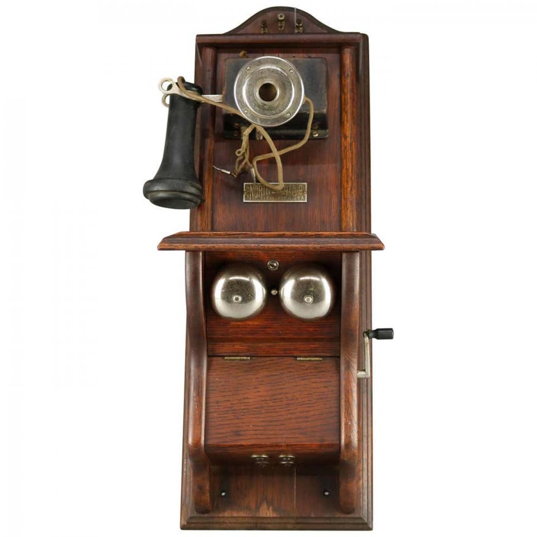 North Electric Paddle Type Oak Wall Telephone, c 1890: An antique paddle type wall telephone by North Electric offers oak case with original hardware, interior components and label as photographed, rings when cranked, c1890. Measures: 25" H x 10.5" W x 10