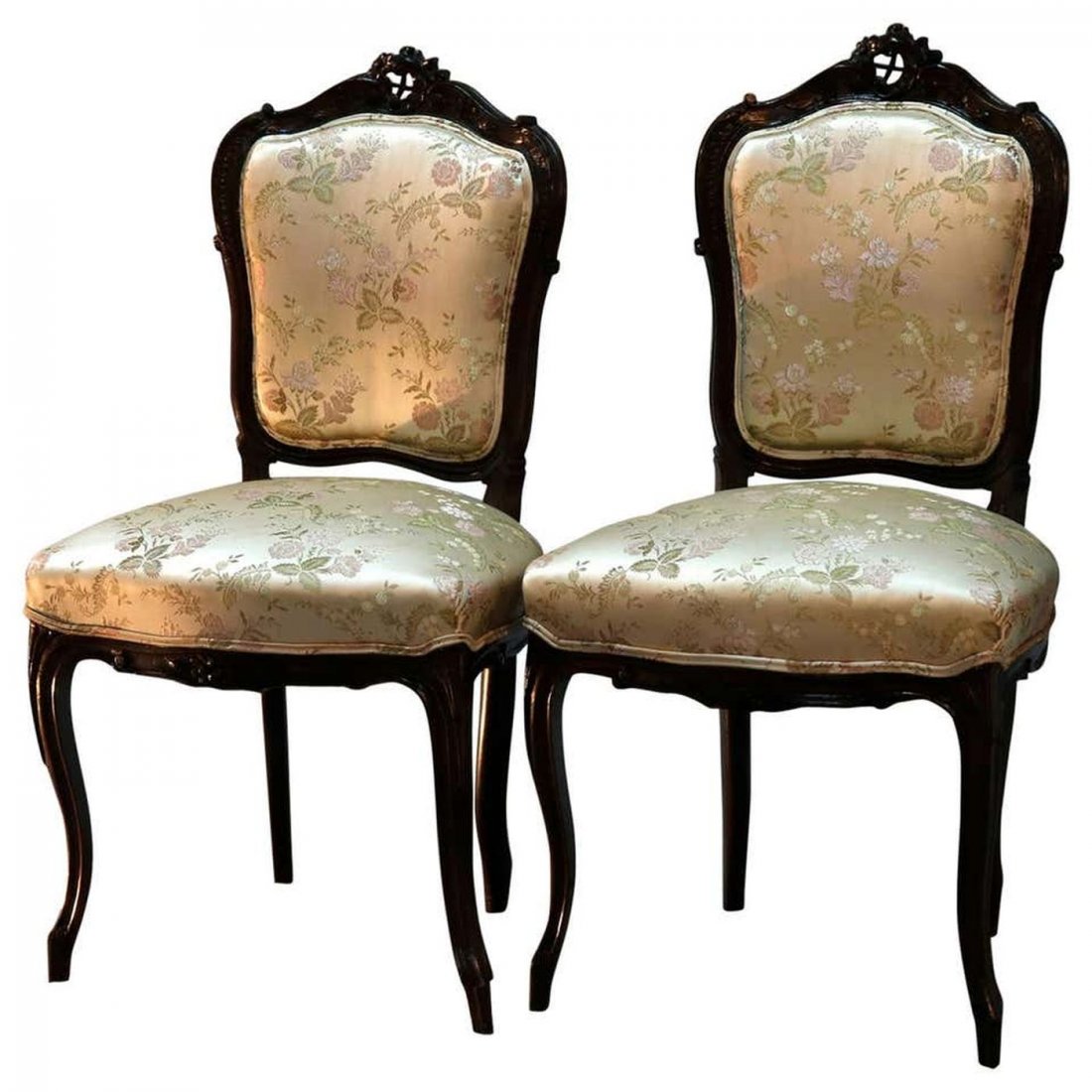 Pair of Louis XV Style Carved Walnut Parlor Side Chair: An antique pair of French Louis XV style parlor side chairs offer walnut frames with carved foliate crests surmounting upholstered backs and seats, raised on cabriole legs, circa 1890. Measures: 36" H
