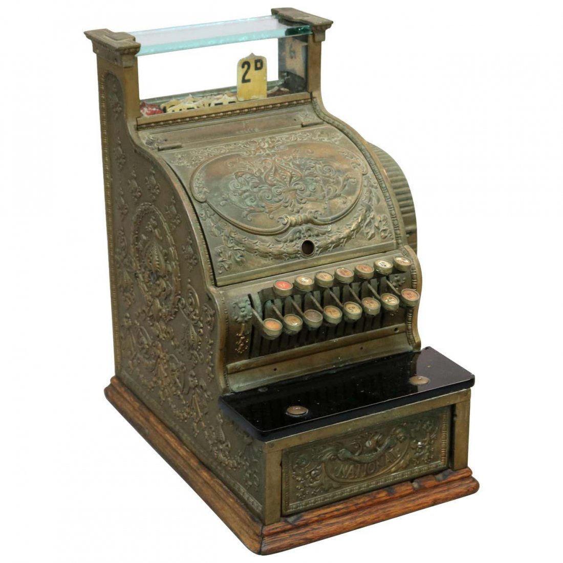 Antique National Candy Store Brass Cash Register, c1900: An antique country store cash register by National offers cast foliate and floral swag brass case having glass display, marble counter and seated on oak base, working and with key, c1900. Measures: 17
