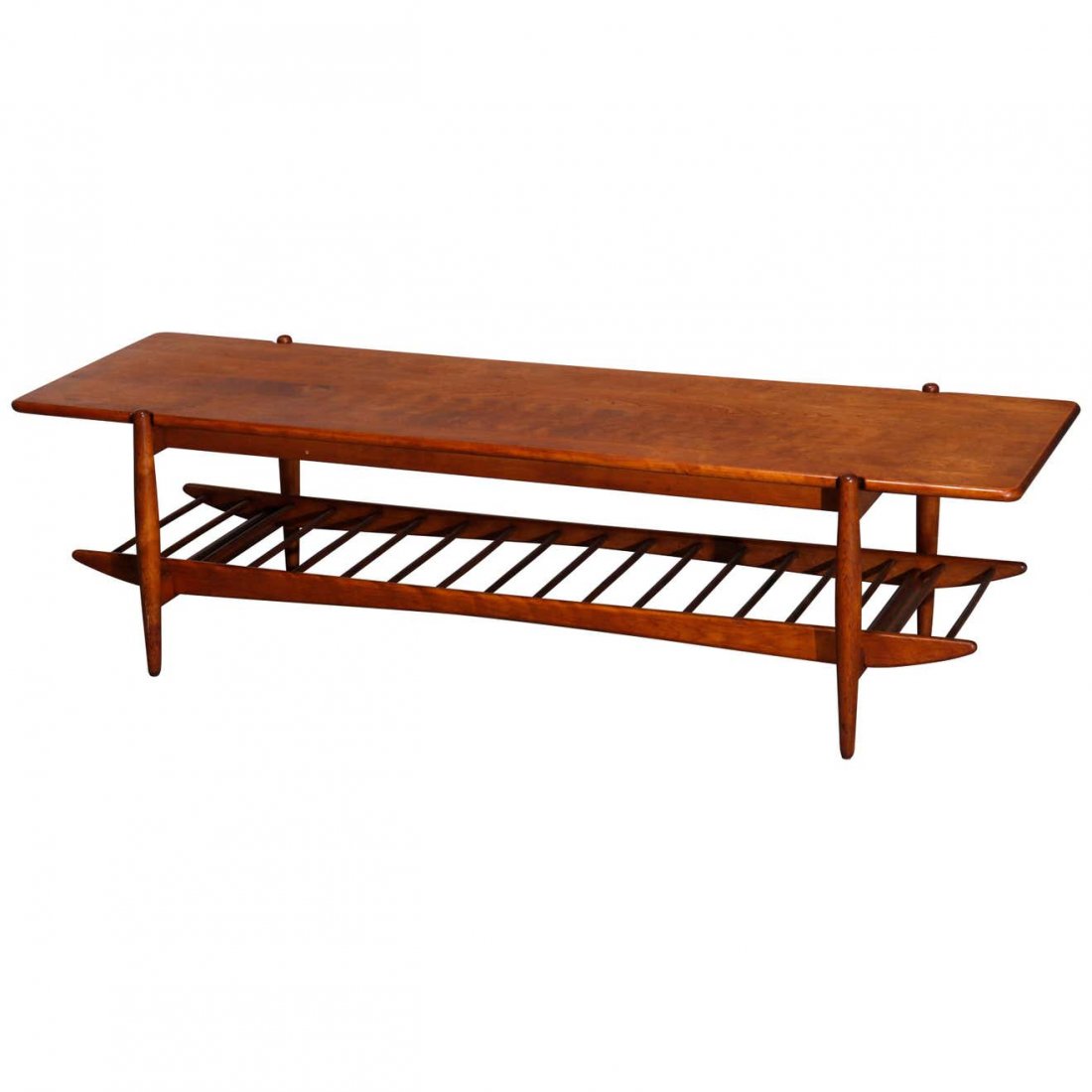 MCM Danish Finn Juhl School Teakwood Coffee Table: An vintage midcentury Danish modern coffee table in the manner of Finn Juhl offers teakwood construction with plank top over ladder form lower display shelf, raised on turned legs, circa 1950. Measure