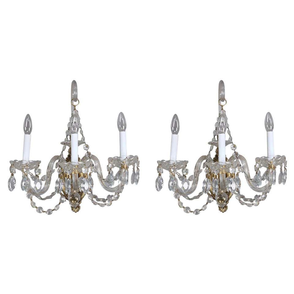 Italian Cut Crystal 3-Light Candle Light Wall Sconces: Pair of Italian wall sconces feature foliate and floral decorated cast wall mounts each with three glass arms terminating in candle lights with strung and hanging cut crystals, newly re-wired, circa 1