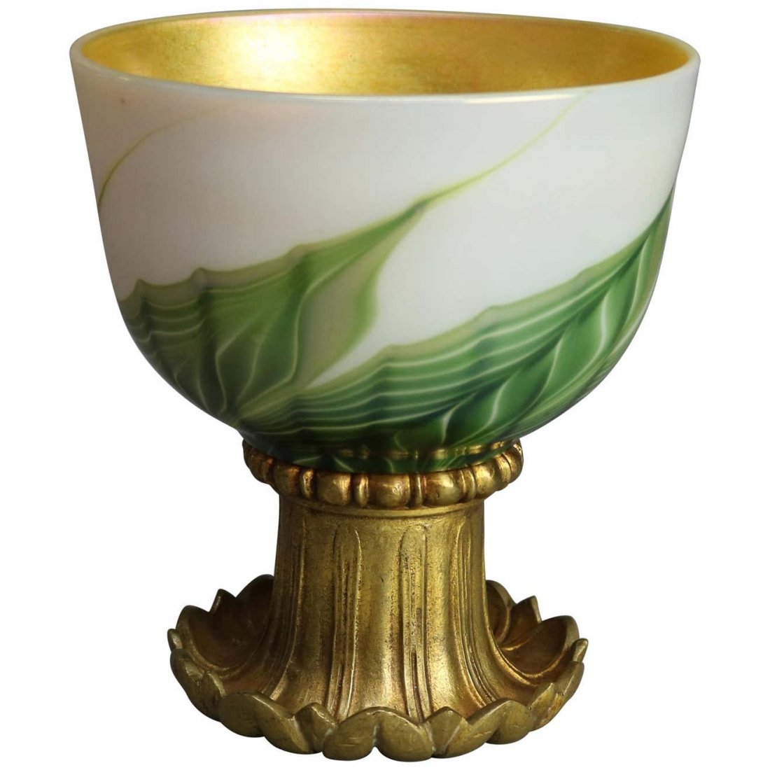 Tiffany Studio Favrile Pulled Feather Art Glass Chalice: An an antique Art Nouveau ceremonial chalice by Tiffany Studio offers Favrile art glass bowl having green, gold and white pulled feather design and gold interior, raised on gilt bronze foliate form ba