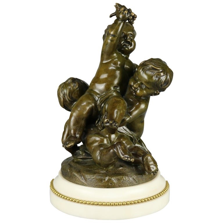 French Bronze Putti Grouping Sculpture by Clodion: An antique French figural cast bronze sculpture grouping depicts classical Greek scene of three playful cherubs (putti) by Claude Michel Clodion (France, 1738-1814), seated on marble plinth, signed on