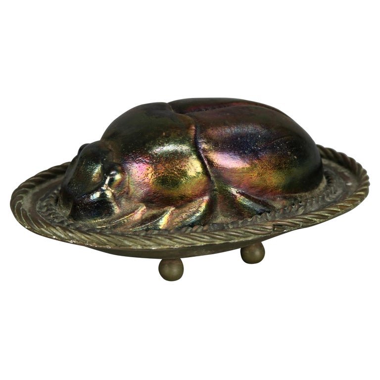 Antique Bronze & Art Glass Scarab After Tiffany: An antique figural sculpture in the manner of Tiffany Studios offers art glass in the form of a scarab (beetle) seated on cast bronze tray having gadroon edge and seated on ball feet, later added stam