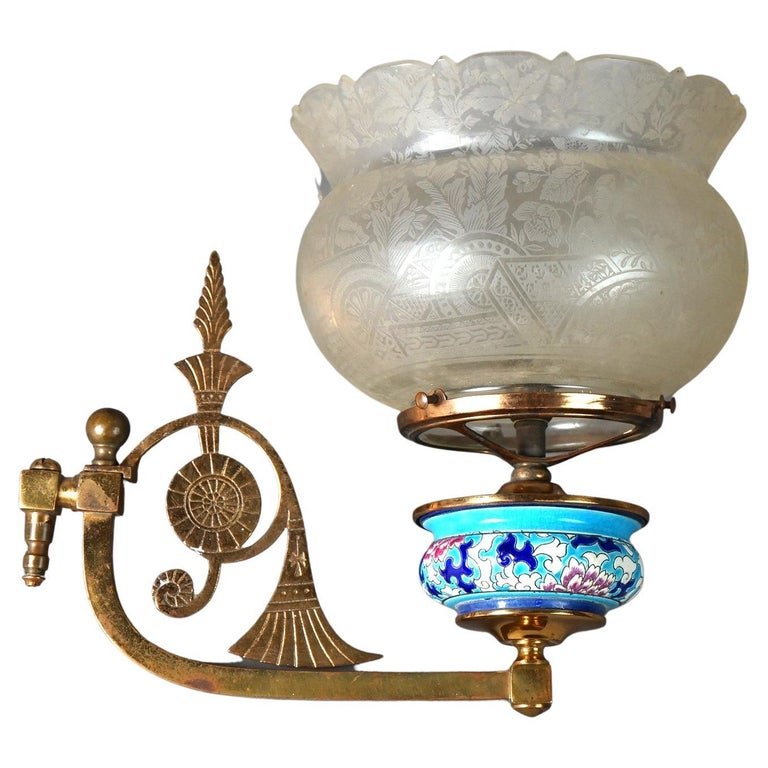 Antique Aesthetic Longwy Pottery Gas Light Wall Sconce Circa 1880: An antique Aesthetic Movement wall oil lamp sconce offers hand painted floral Longwy Pottery font on cast brass arm with stylized fan design and having etched frosted glass shade, circa 1880. Measures