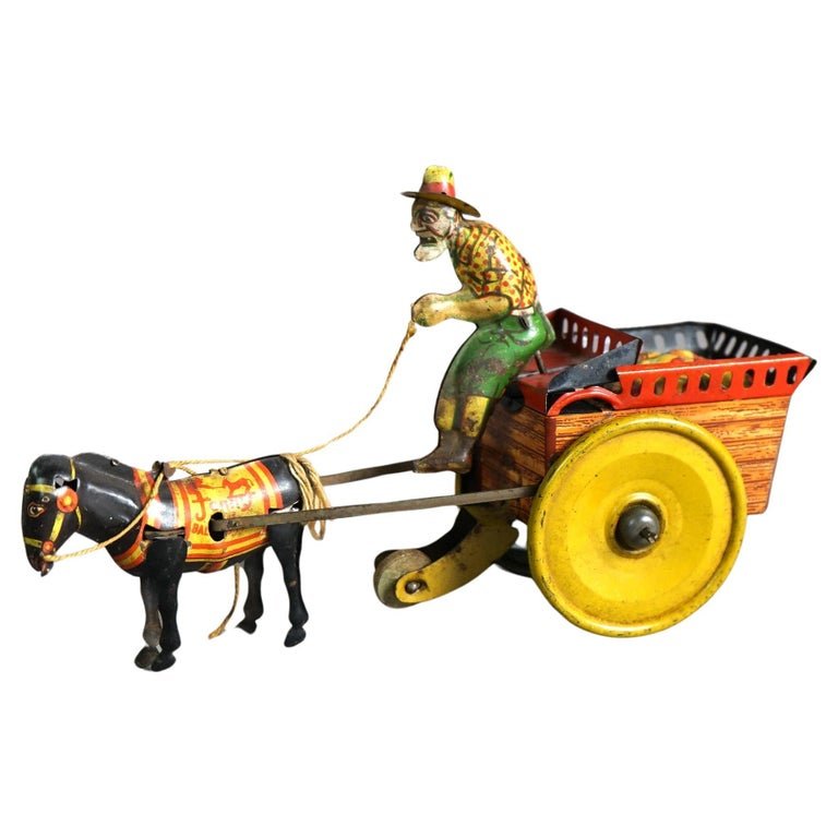 Antique Tin Wind-Up Toy by The Ferdinand Strauss Corp; Man, Mule & Wagon; c1920: An antique wind up toy by The Ferdinand Strauss Corp. offers painted tin plate construction and depicts a mule drawn cart with a man, circa 1920. Measures- 5.25''H x 3.25''W x 8.75''D. *** OPTIONAL SH