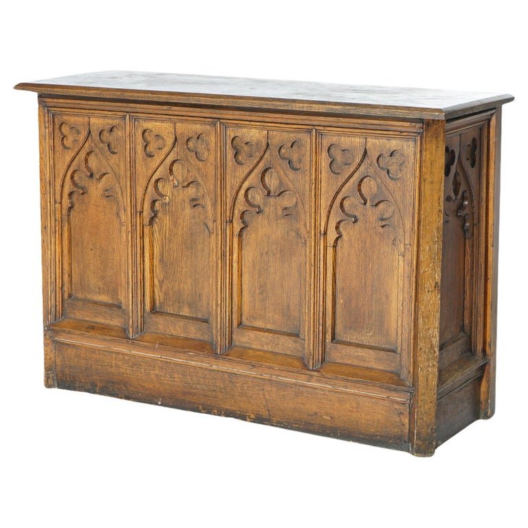 Antique Gothic Revival Carved Quarter Sawn Oak Paneled Console Table 19thC: An antique Gothic Revival console table offers quarter sawn oak paneled construction with carved stylized arches, 19th century. Measures - 27"h x 40"w x 14"d. *** OPTIONAL SHIPPING & DELIVERY - While