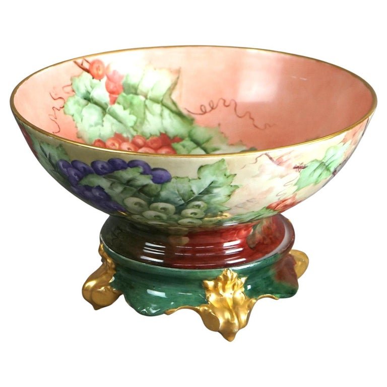 Antique Limogés Porcelain Hand Painted Grape & Gilt Punch Bowl on Pedestal C1900: An antique French Limogés punch bowl by Tressemann & Vogt offers porcelain construction with hand painted grape and vine decoration, gilt highlights throughout, en verso T&V maker stamp, and raised o