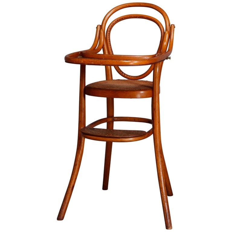 Antique German Bentwood & Cane Child's High Chair by Michael Thonet 19th Century: An antique German child's high chair by Michael Thonet offers bentwood construction with caned seat, feeding tray and footrest, original label as photographed, mid-19th century. Measures: 38" H x 18.5