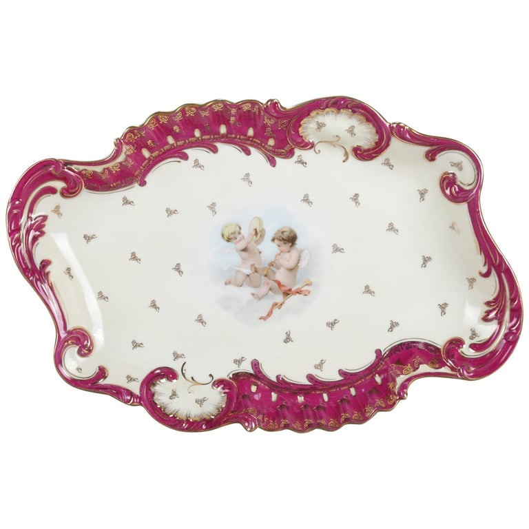 15" German Classical Dresden School Hand Painted and Gilt Porcelain Platter: An antique German Dresden School porcelain platter features scroll and gadroon rim with central Classical cherub scene, allover gilt decorated, en verso beehave mark, circa 1890. Measures: 2.25" H x 1